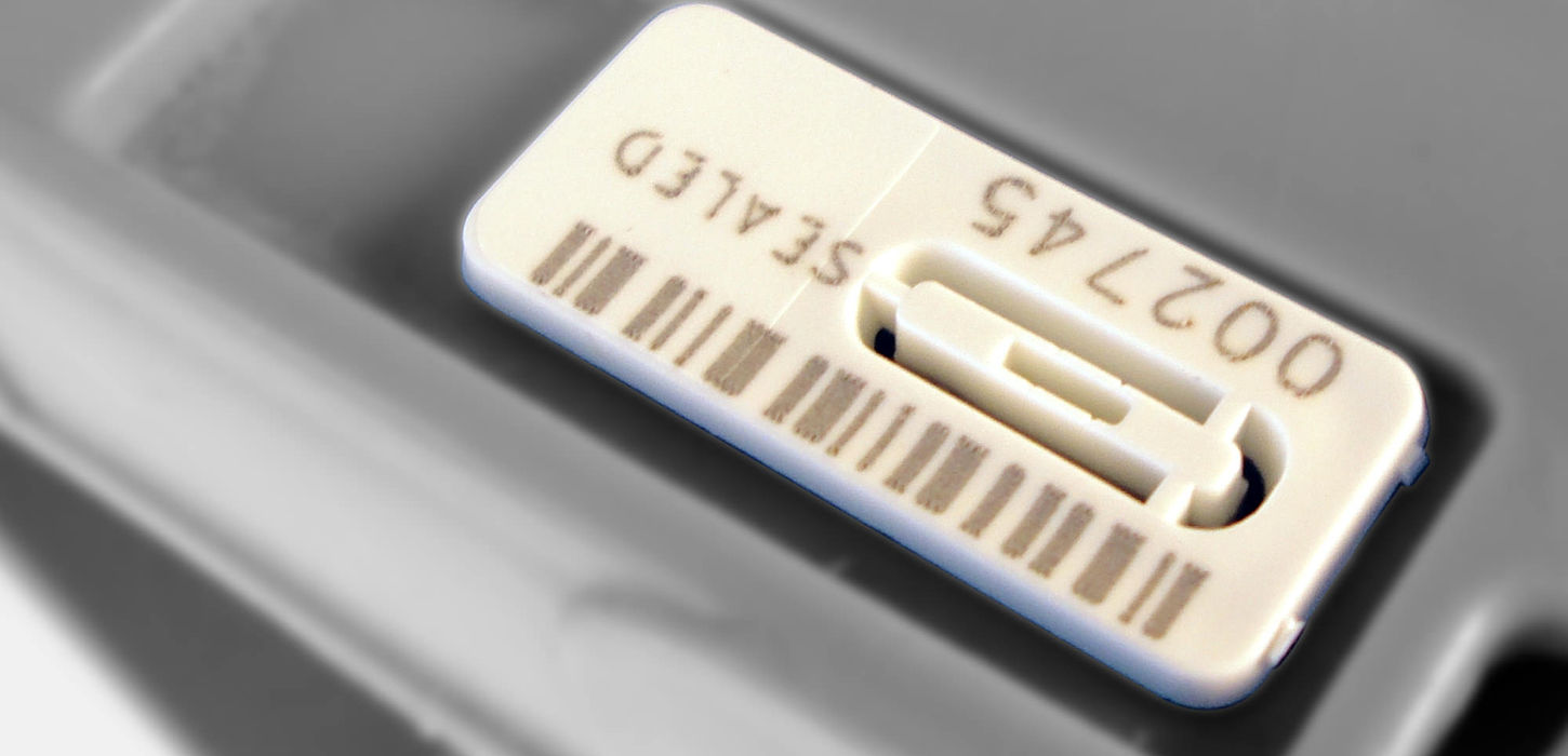 Unisto Syntra Grand snap-on security seal applied to a box, close-up